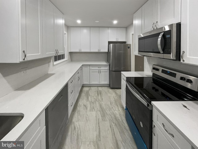 kitchen with decorative backsplash, sink, white cabinets, and stainless steel appliances