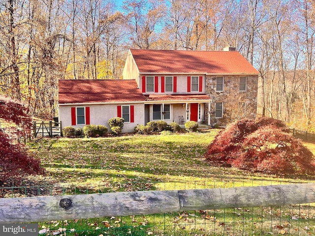 colonial home with a front lawn