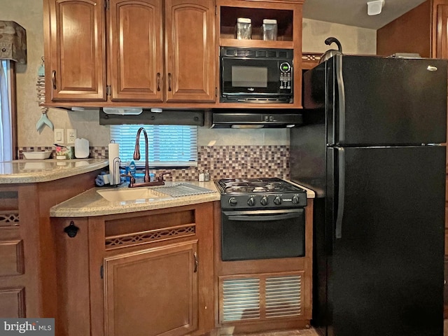 kitchen featuring backsplash, sink, black appliances, and ventilation hood