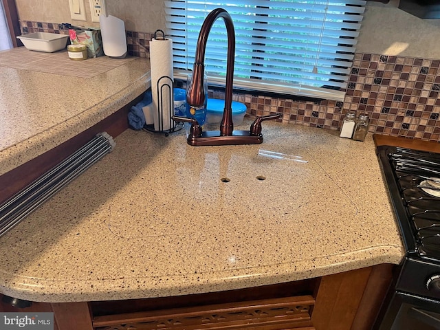 details featuring tasteful backsplash and black stove