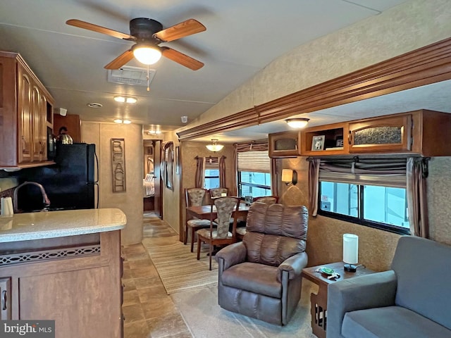 living room featuring ceiling fan, sink, and lofted ceiling