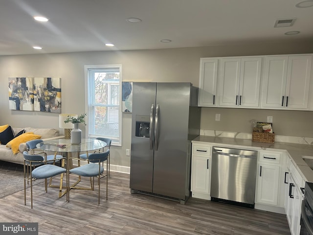 kitchen featuring dark hardwood / wood-style floors, white cabinetry, and stainless steel appliances