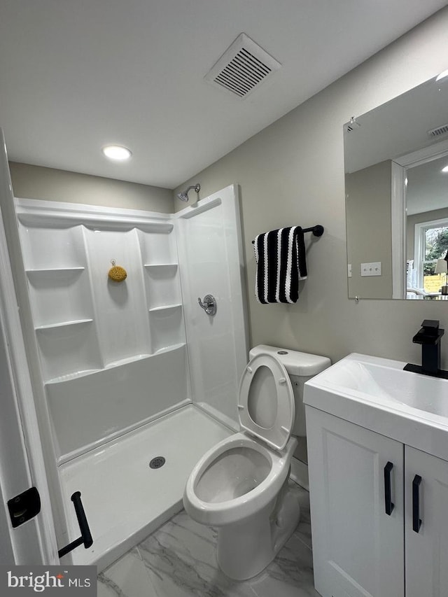 bathroom featuring vanity, toilet, and a shower