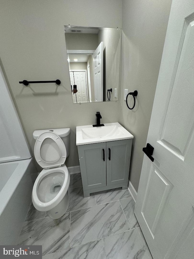 bathroom featuring vanity, toilet, and a tub