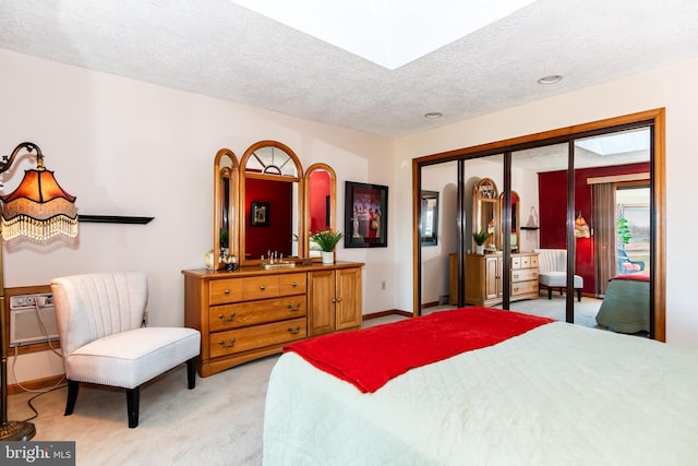 bedroom featuring a textured ceiling, light colored carpet, and a closet