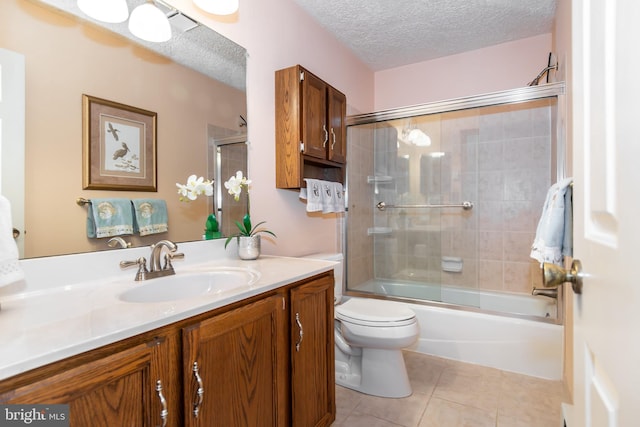 full bathroom featuring combined bath / shower with glass door, tile patterned floors, vanity, a textured ceiling, and toilet