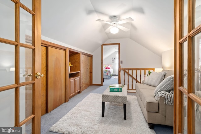 living room with ceiling fan, lofted ceiling, and light carpet