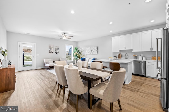 dining room with light wood-style floors, ceiling fan, baseboards, and recessed lighting