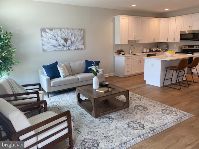 living room featuring recessed lighting, baseboards, and wood finished floors