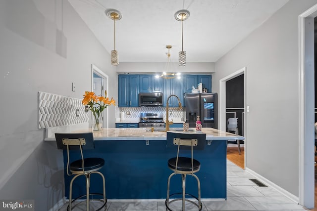 kitchen featuring kitchen peninsula, decorative light fixtures, a kitchen bar, and stainless steel appliances