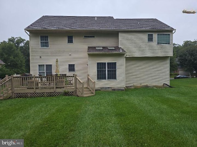 rear view of property with a deck and a lawn