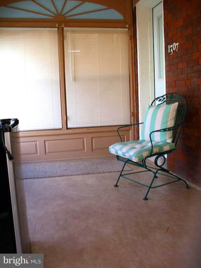 interior space featuring concrete floors and brick wall