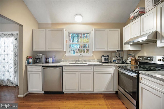 kitchen featuring white cabinets, sink, appliances with stainless steel finishes, and light hardwood / wood-style flooring