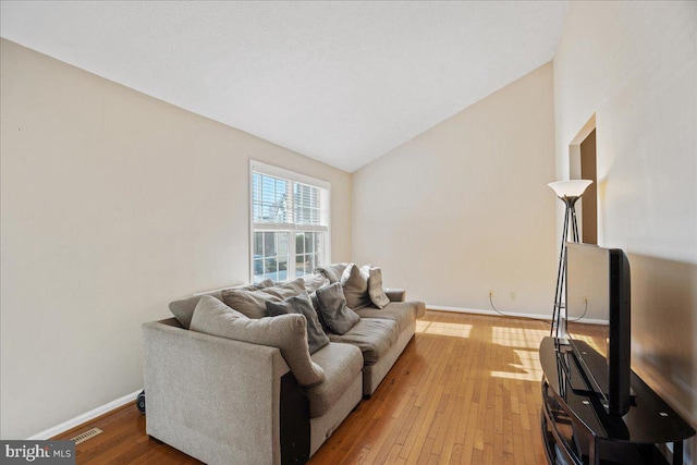 living room featuring lofted ceiling and wood-type flooring