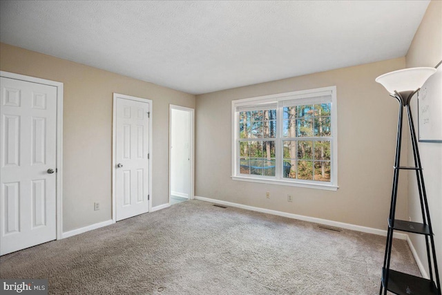 unfurnished bedroom featuring carpet flooring and a textured ceiling