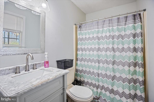 bathroom featuring curtained shower, vanity, a textured ceiling, and toilet