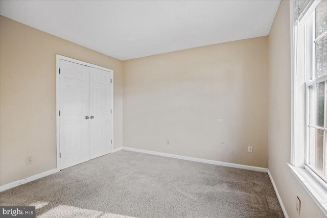 unfurnished bedroom with carpet and multiple windows