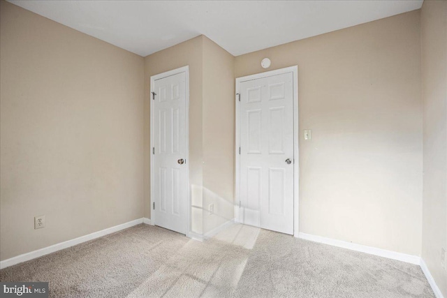 unfurnished bedroom featuring light carpet