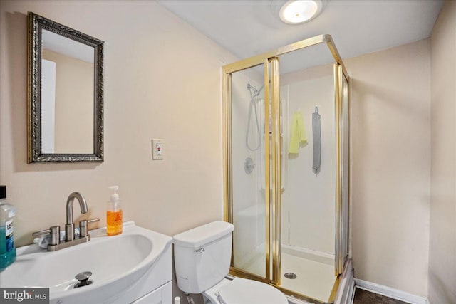 bathroom with vanity, a shower with shower door, and toilet