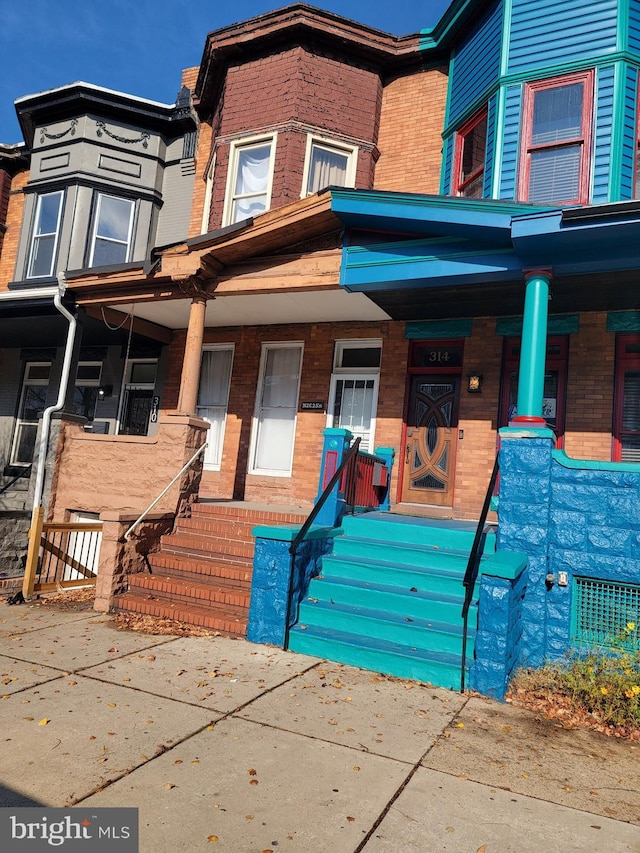 townhome / multi-family property featuring covered porch