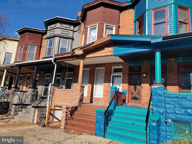 townhome / multi-family property featuring covered porch