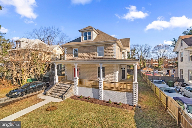 view of front of home featuring covered porch and a front lawn