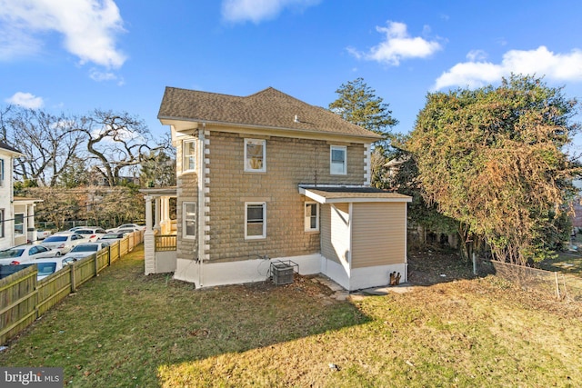 back of house featuring a lawn and central AC