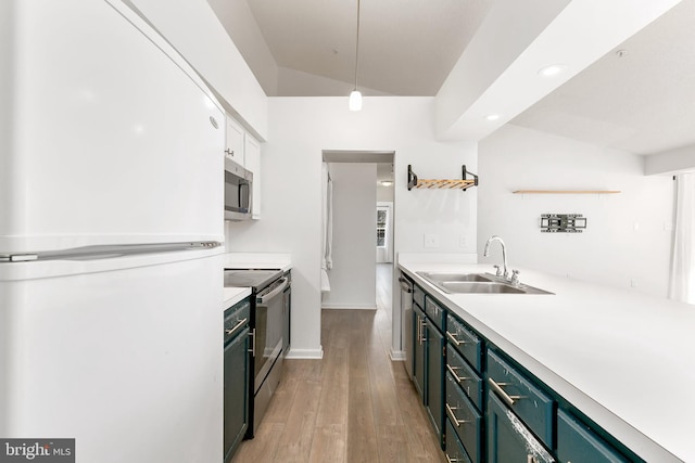 kitchen with sink, white refrigerator, black electric range oven, hanging light fixtures, and lofted ceiling