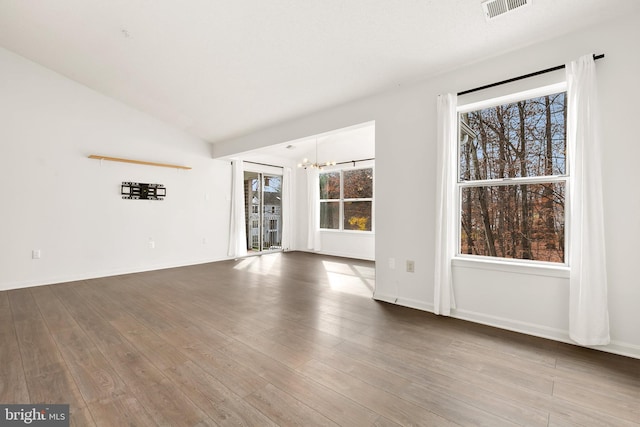 unfurnished living room featuring a wealth of natural light, hardwood / wood-style floors, and vaulted ceiling