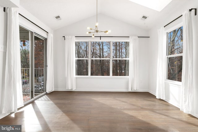 unfurnished dining area with a healthy amount of sunlight, lofted ceiling, and wood-type flooring