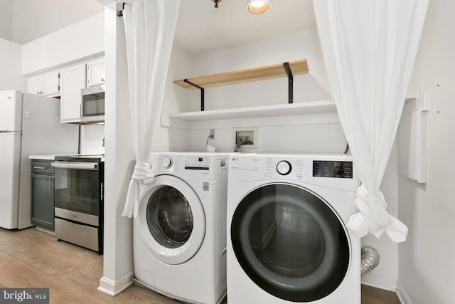 laundry room with washer and dryer and light hardwood / wood-style flooring