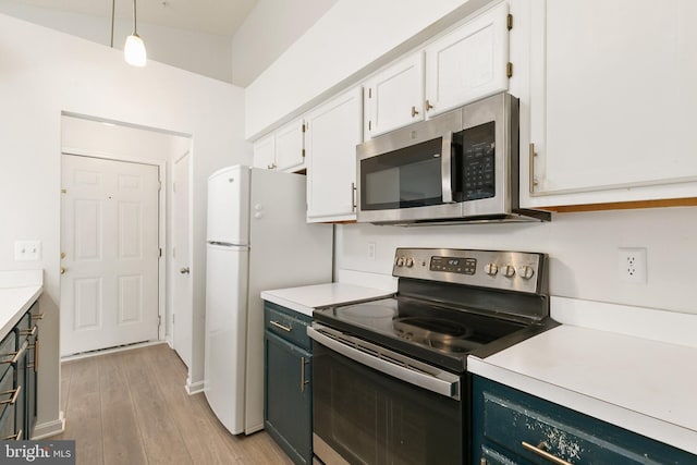 kitchen featuring pendant lighting, light wood-type flooring, white cabinetry, and appliances with stainless steel finishes