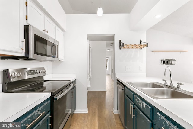 kitchen featuring sink, hanging light fixtures, light hardwood / wood-style flooring, white cabinetry, and stainless steel appliances