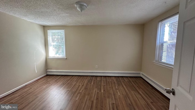 unfurnished room with dark hardwood / wood-style flooring and a textured ceiling