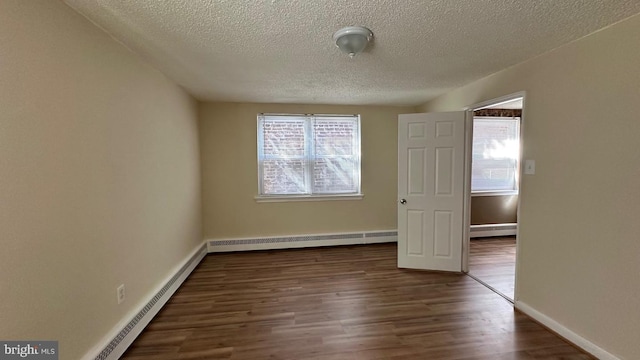 unfurnished room featuring dark hardwood / wood-style flooring, a textured ceiling, and a baseboard radiator