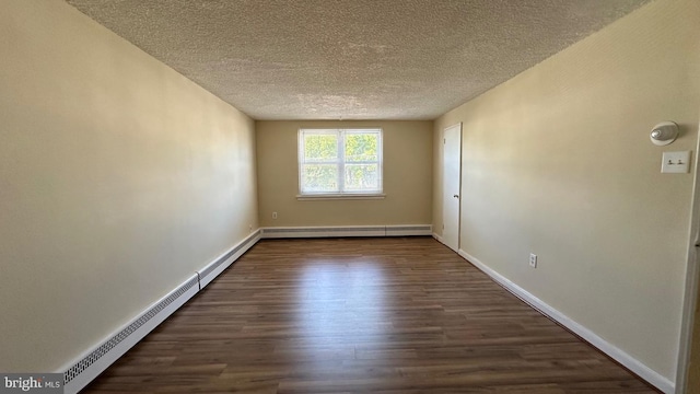 spare room with baseboard heating, dark hardwood / wood-style flooring, and a textured ceiling