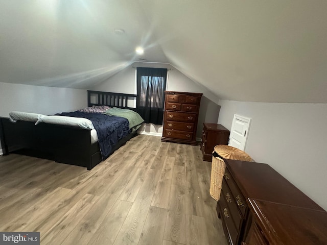 bedroom with light hardwood / wood-style flooring and lofted ceiling