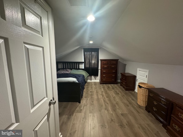 bedroom featuring light hardwood / wood-style flooring and lofted ceiling