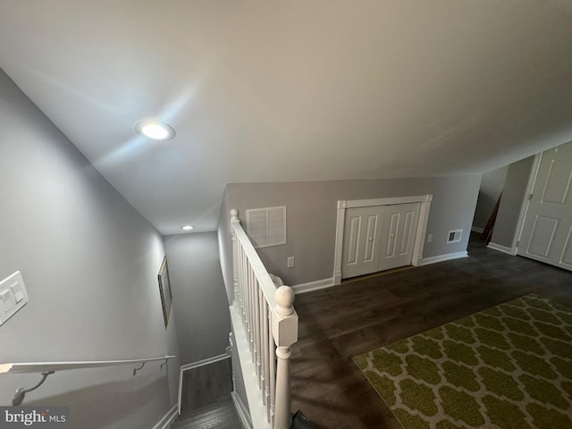 stairway with wood-type flooring and vaulted ceiling