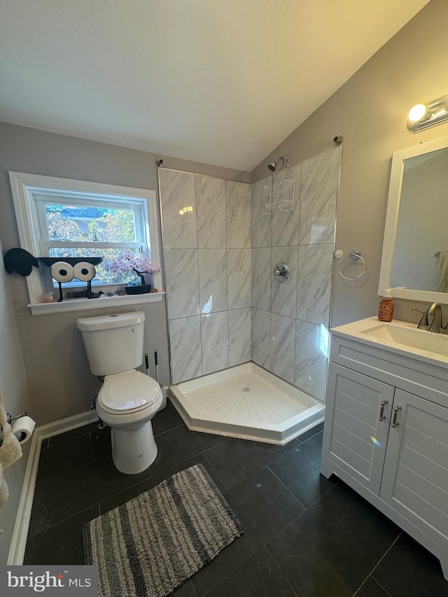 bathroom featuring vanity, tile patterned floors, vaulted ceiling, toilet, and a tile shower