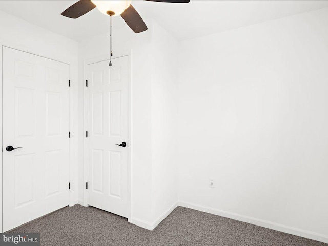 interior space with dark colored carpet and ceiling fan