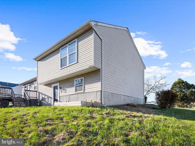 exterior space featuring a deck, a yard, and central AC