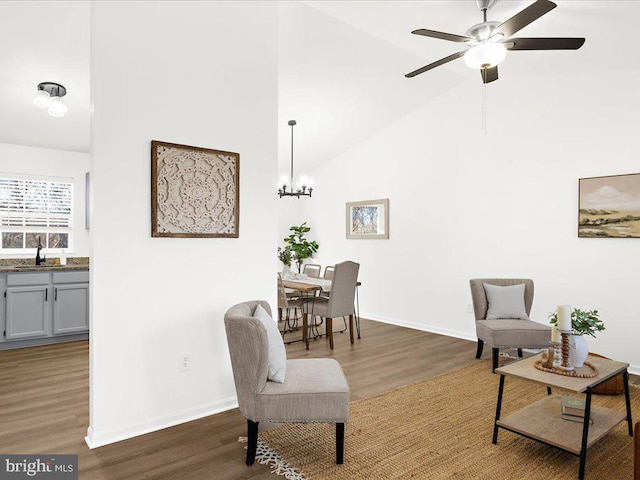 sitting room featuring ceiling fan with notable chandelier, dark hardwood / wood-style flooring, high vaulted ceiling, and sink