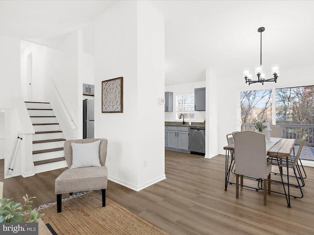 dining area with a notable chandelier, dark hardwood / wood-style flooring, and sink