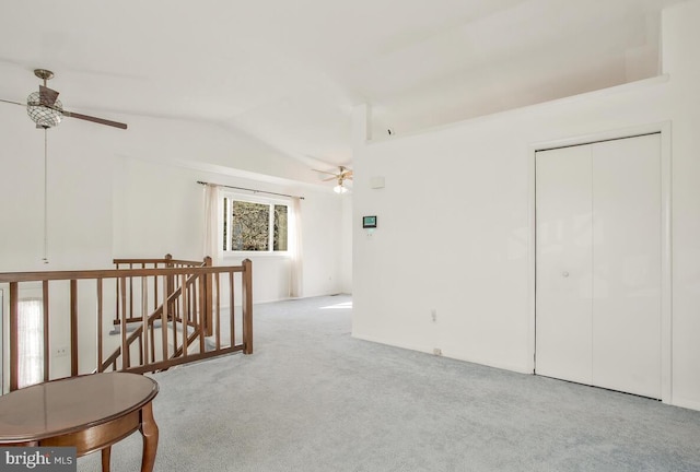 carpeted spare room with ceiling fan and lofted ceiling