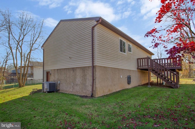 view of side of home featuring a lawn, central air condition unit, and a wooden deck