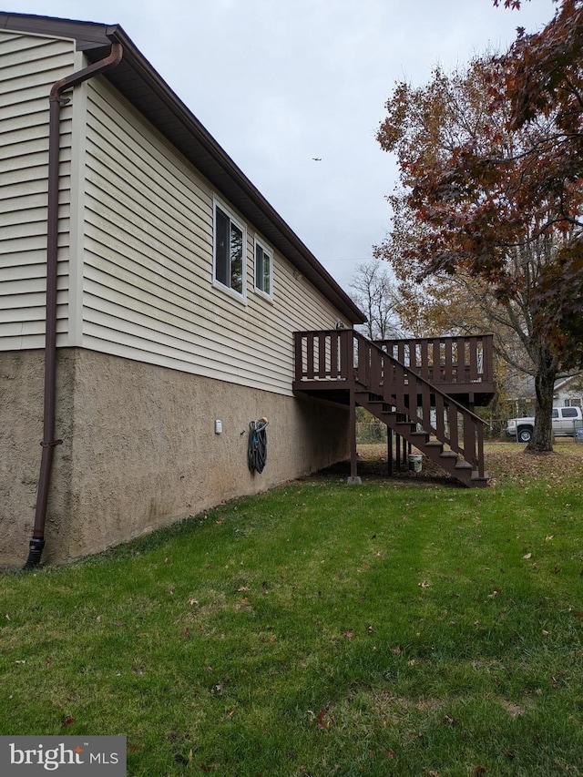 view of side of property with a lawn and a deck