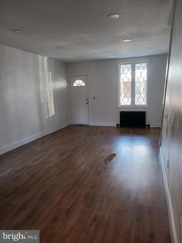 entrance foyer featuring dark hardwood / wood-style floors and radiator