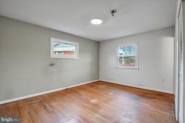 spare room with plenty of natural light and hardwood / wood-style flooring