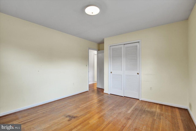 unfurnished bedroom featuring light hardwood / wood-style flooring and a closet